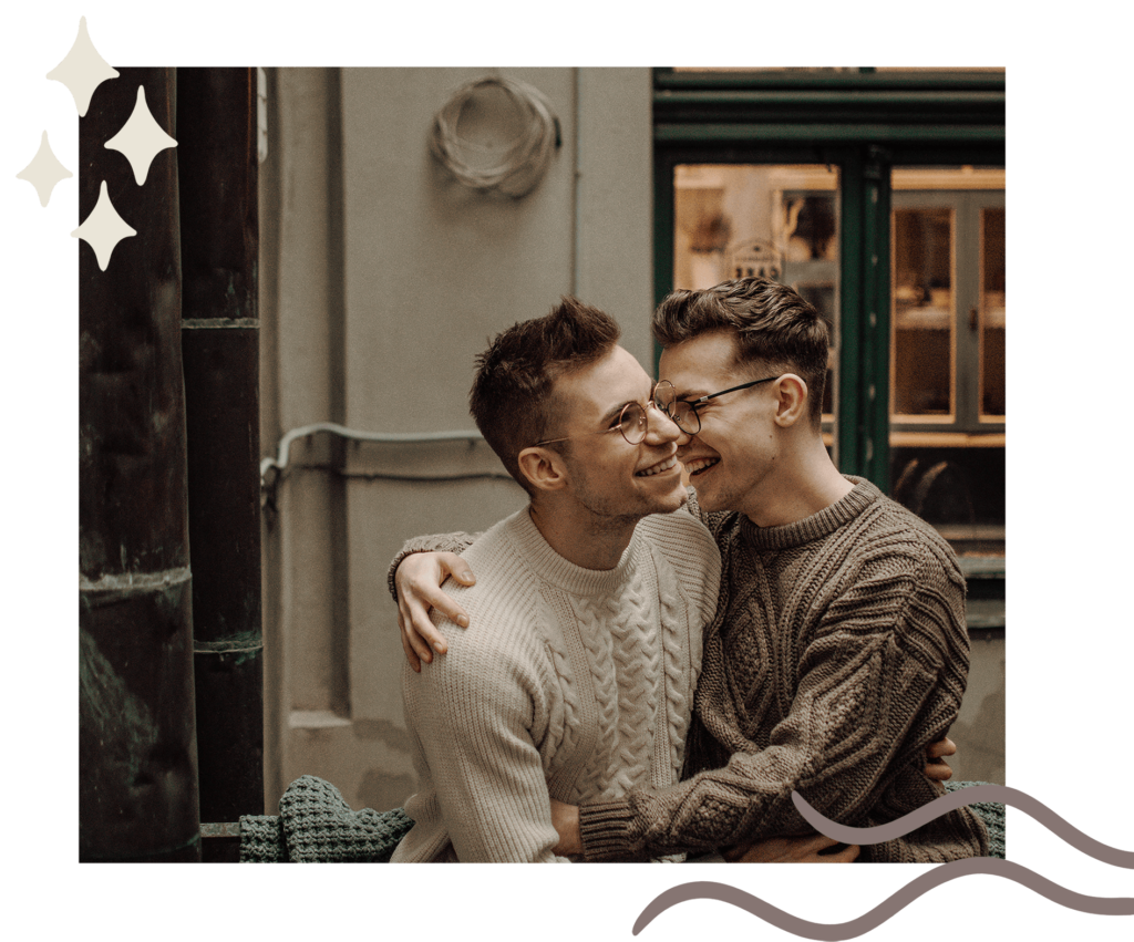 two men embracing each other sitting in front of a shop window