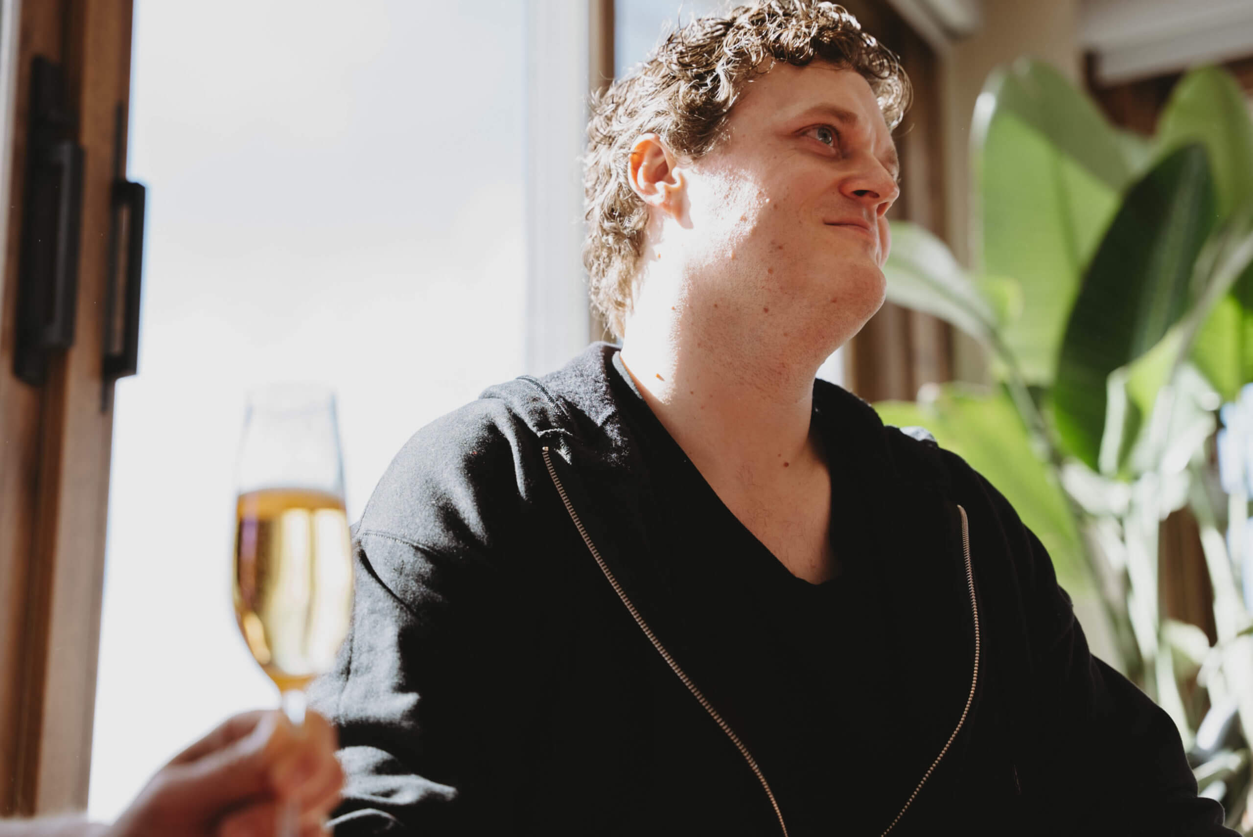 man sitting in front of large windows looking up