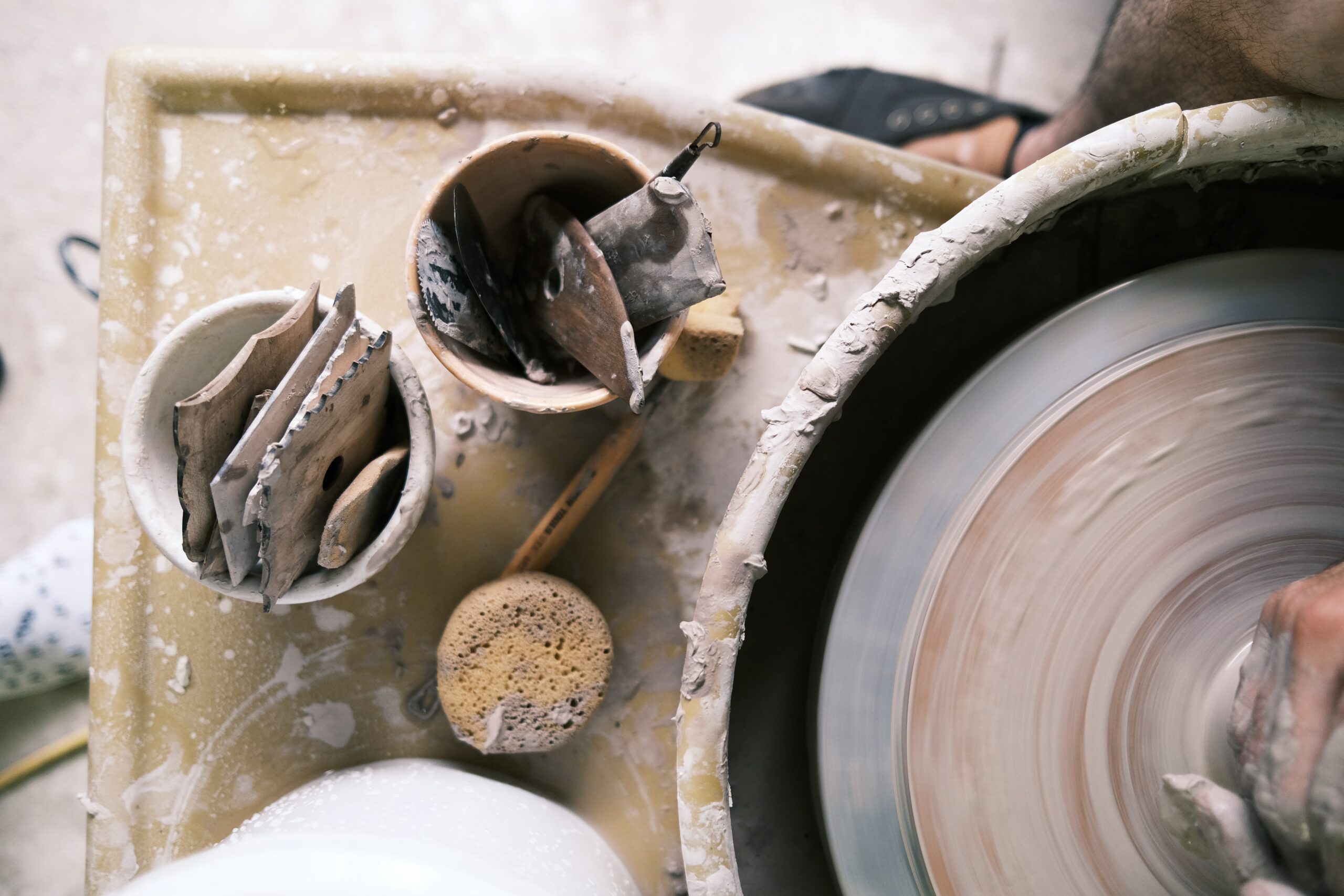 Journal close up of a table with pottery tools and a pottery wheel