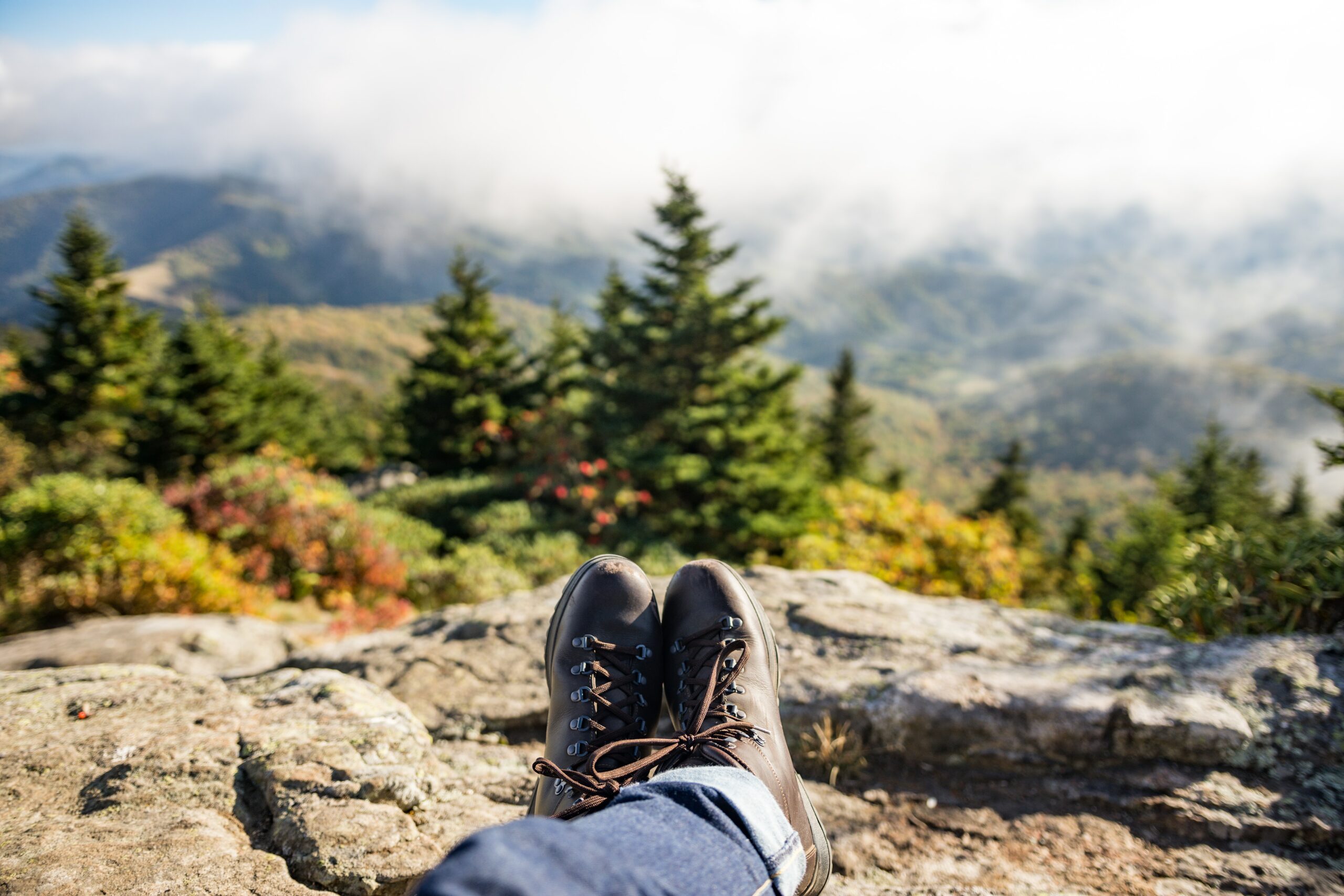 Journal pair of brown boots overlooking a rocky edge in the mountains