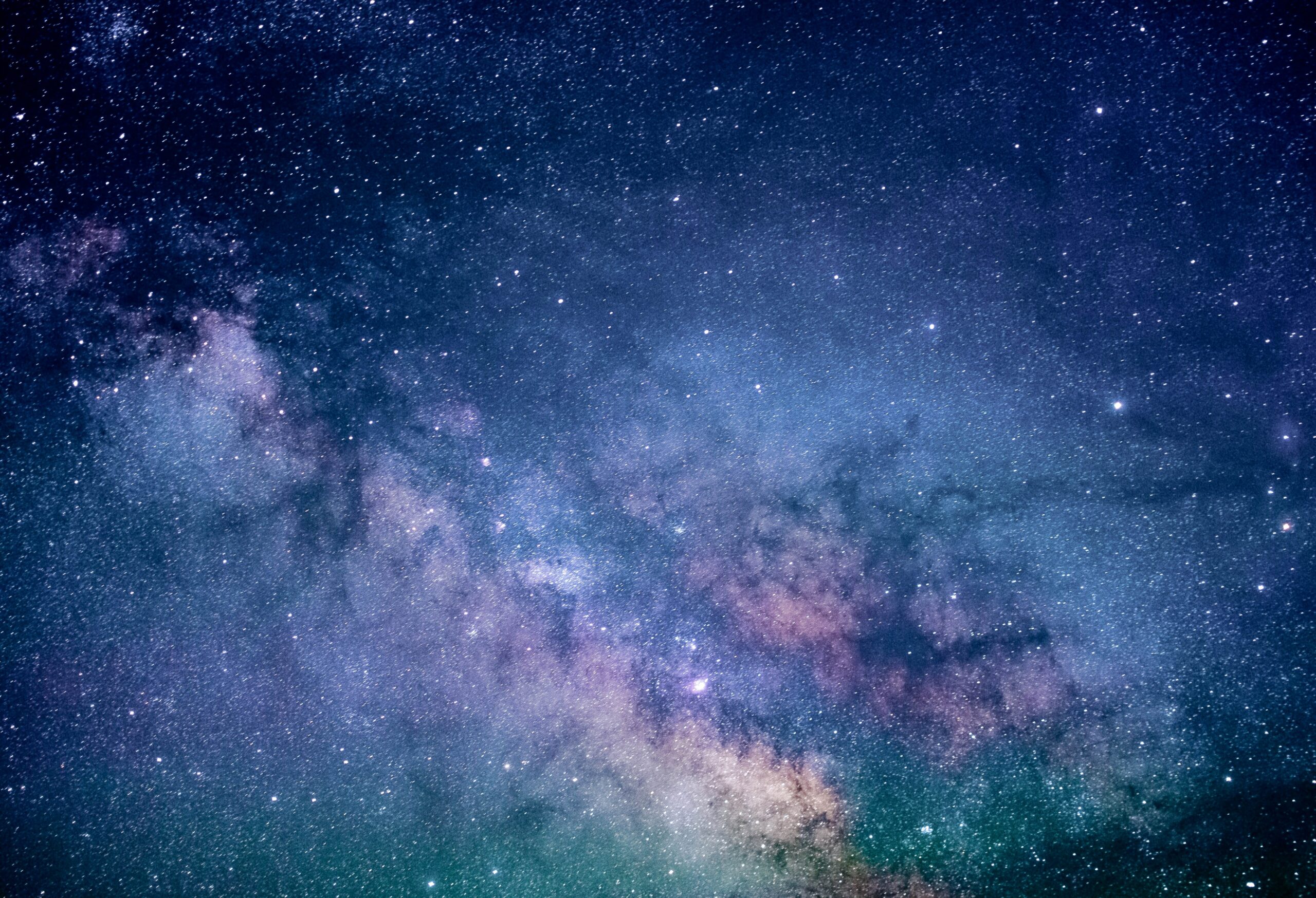 close up of night sky with blue and purple stars
