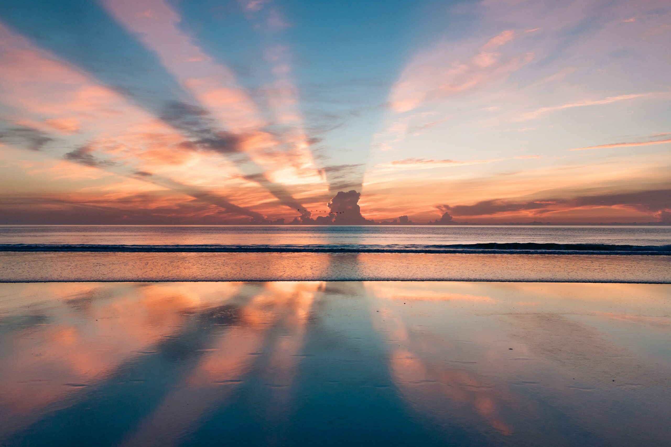 Journal a blue, pink, and orange sunset over a large body of calm water